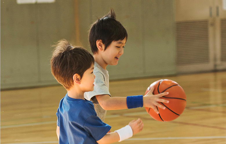 2人の少年がバスケットボールをする様子