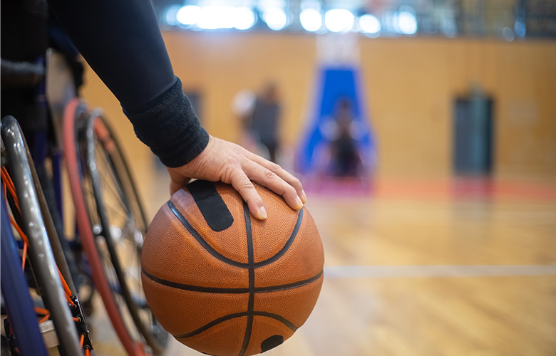 車いすに乗りながらバスケットボールを持っている男性