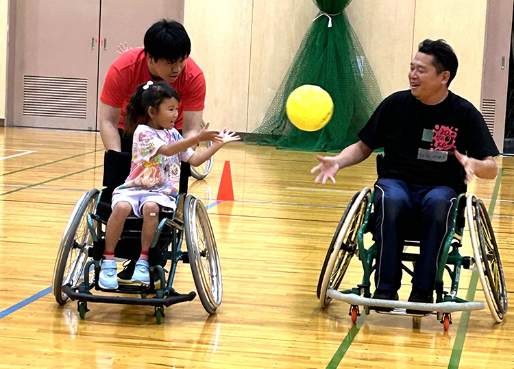車いすに乗りながらボールをパスしあう様子